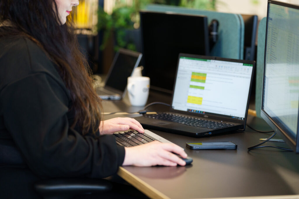 a close up of a person working at a computer, using a mouse and keyboard