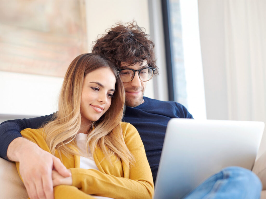 A couple who are clients of ONP Solicitors tracking their case and making a payment online with their laptop