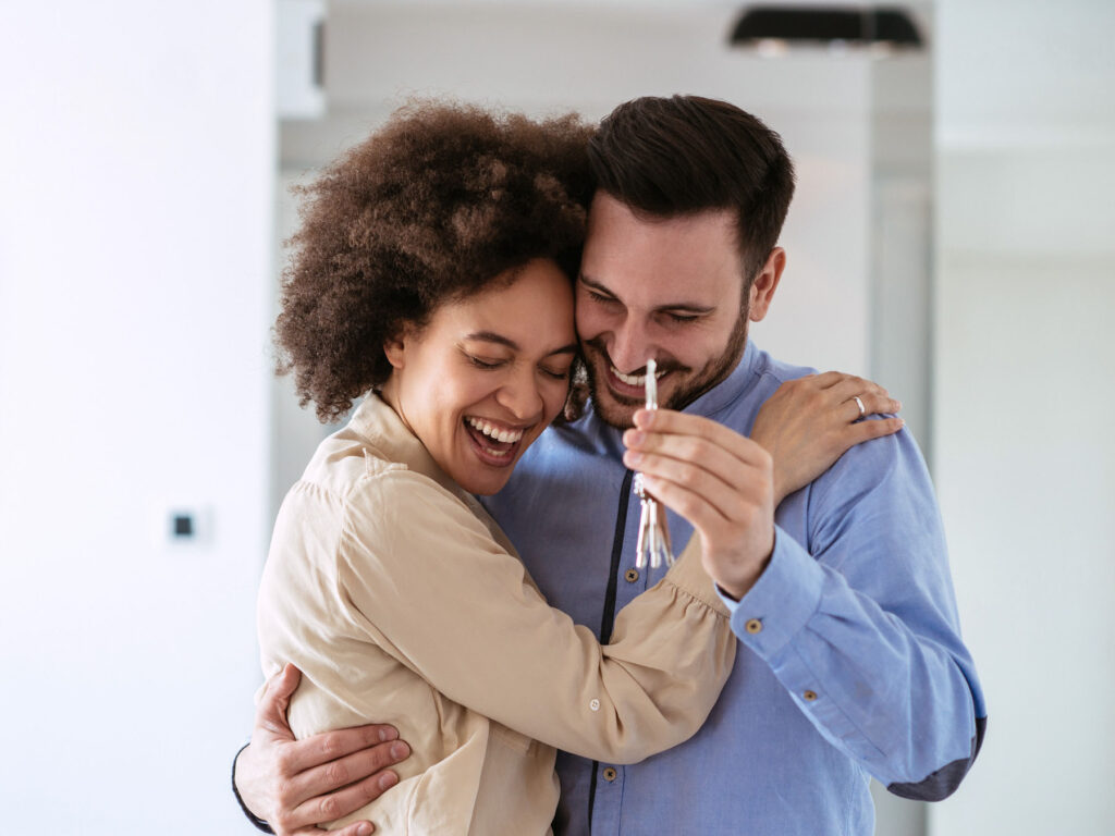 A couple who are new home owners holding the keys to their property after using ONP Solicitor's conveyancing and legal services