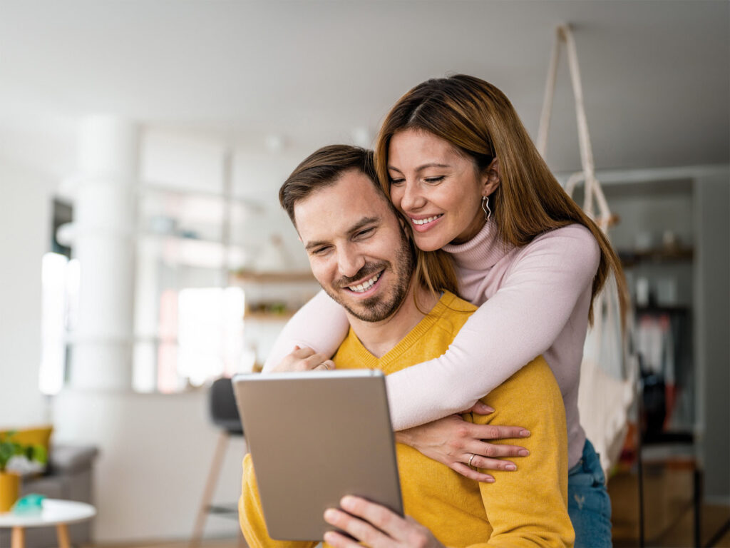 A couple researching ONP Solicitor's conveyancing services on a tablet